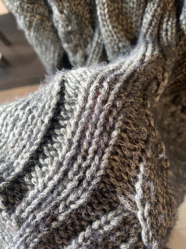 Macro of a sweater with intertwined color and fabrics with more blue tones visible