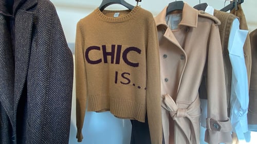 Sweater hanging with text "chic is..."