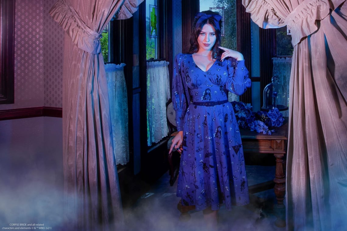 “A tragic tale of romance, passion...and murder most foul.” Inspired by Tim Burton’s CORPSE BRIDE™. All the characters from the film are recreated in this original whimsical conversational print! This comfortable, yet dramatic dress features shirred sleeves with long Victorian-style cuffs, shirred bust, fitted waist, an A-line flared mid-calf skirt, and pockets!